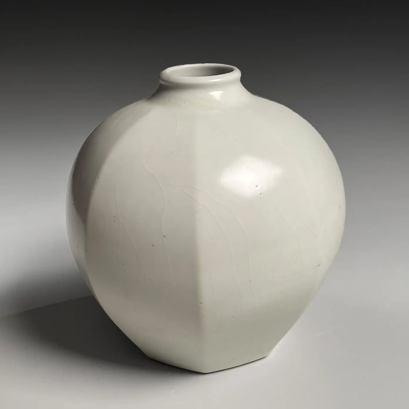 TOMIMOTO KENKICHI, Faceted white porcelain vessel with narrow, upraised neck, 1932