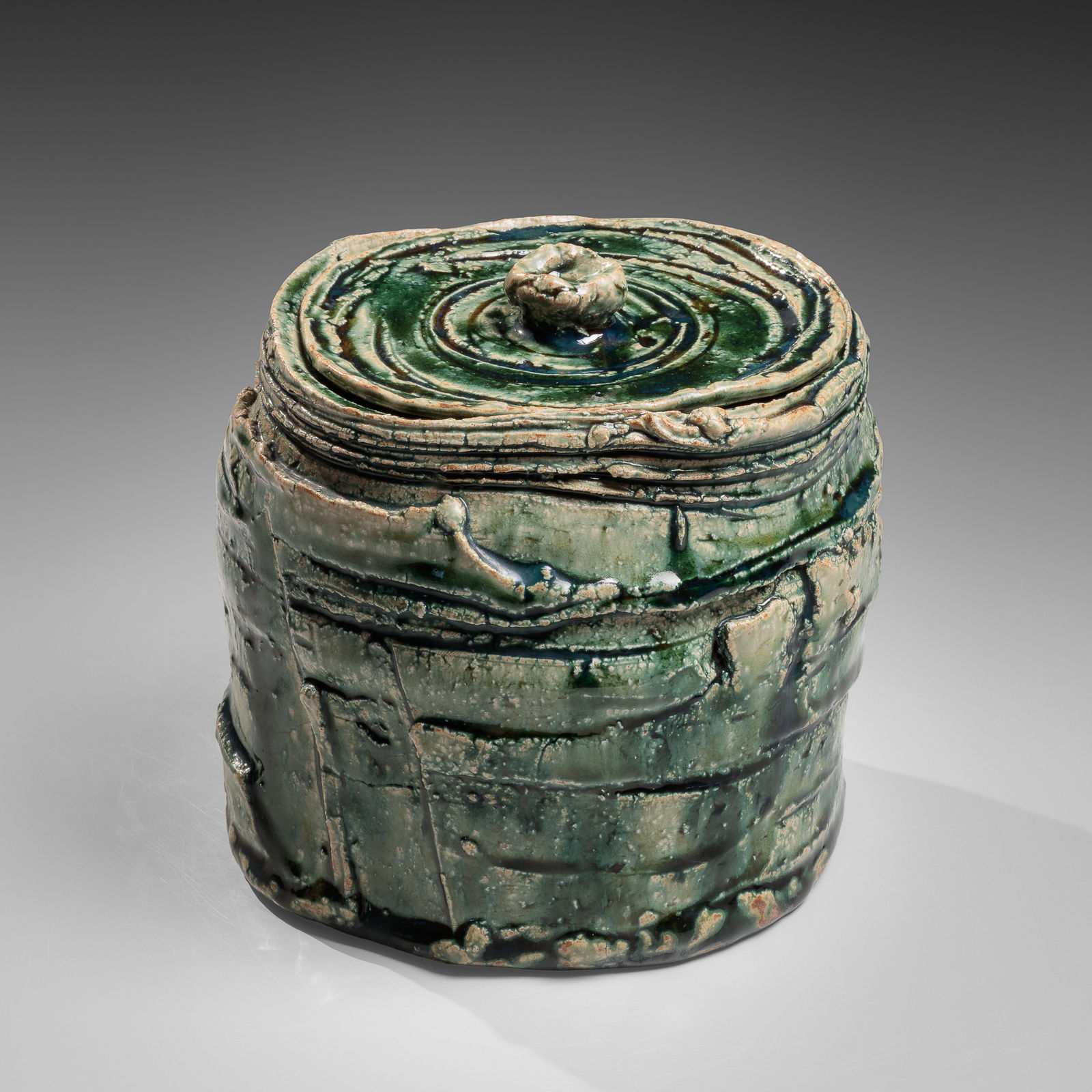 OKABE MINEO, Oribe-glazed round waterjar with carved banding and matching circular cover, ca. 1964