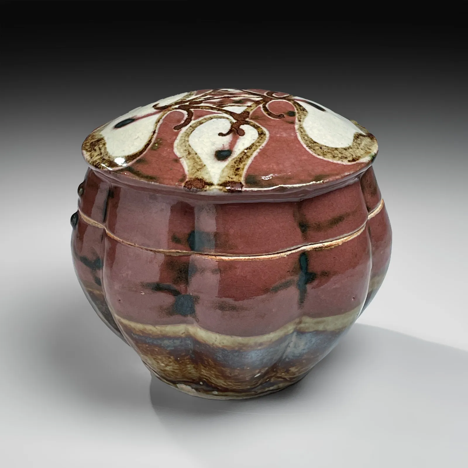 KAWAI KANJIRŌ, Red copper-glazed, lobed, covered box with floral design, ca. 1950