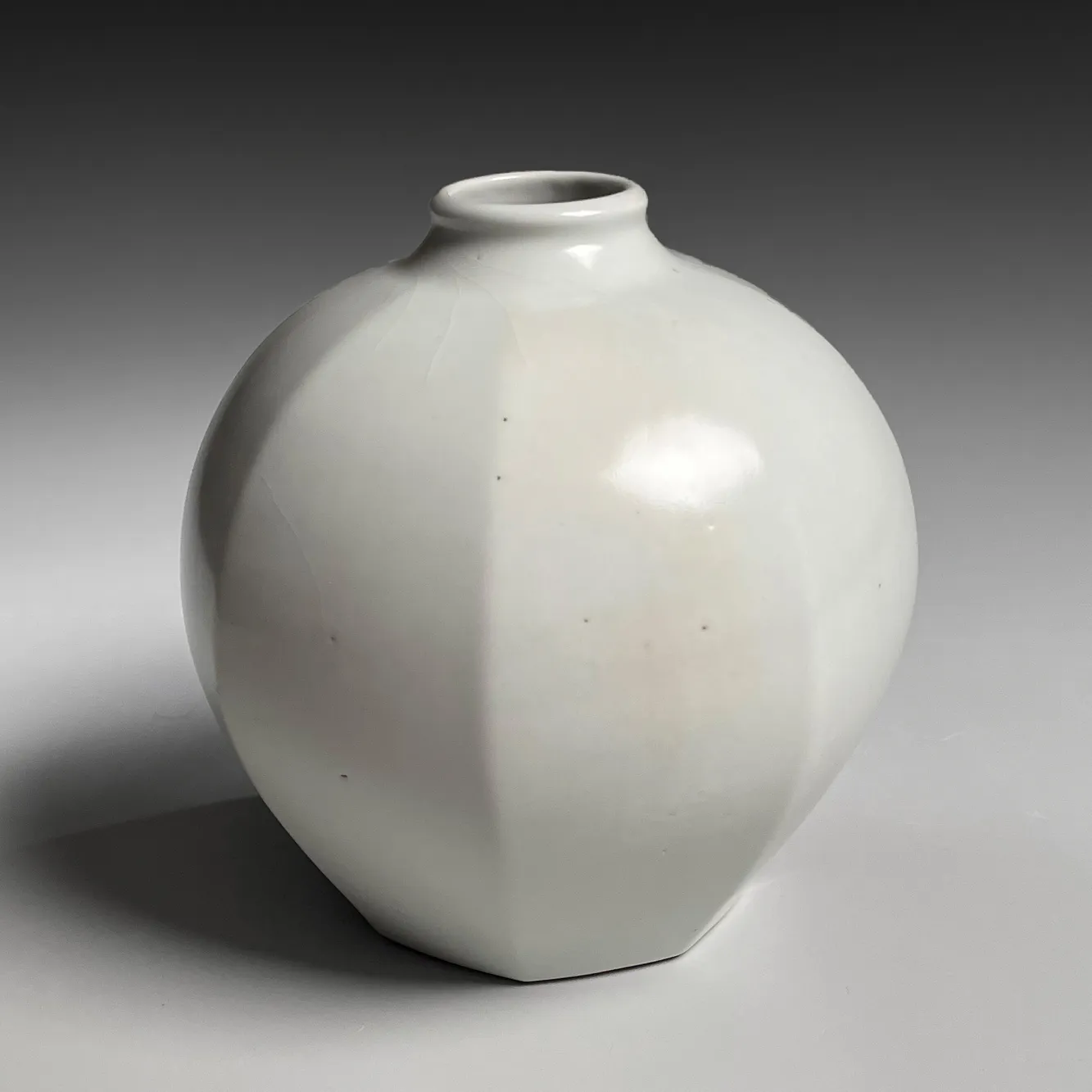 TOMIMOTO KENKICHI, Faceted white porcelain vessel with narrow, upraised neck, 1932