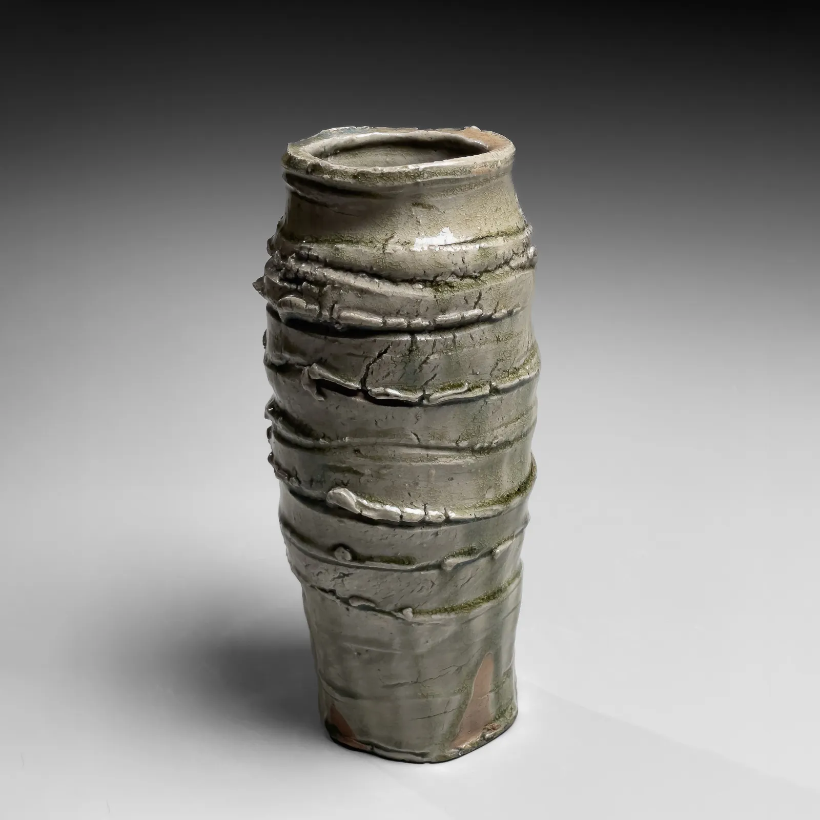 OKABE MINEO, Ash-glazed columnar vessel with irregular carved banding, 1963