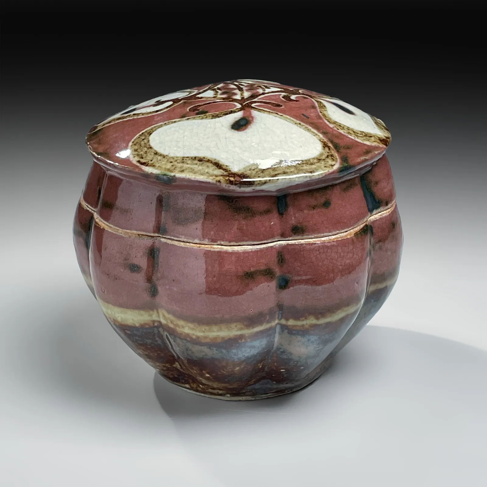 KAWAI KANJIRŌ, Red copper-glazed, lobed, covered box with floral design, ca. 1950