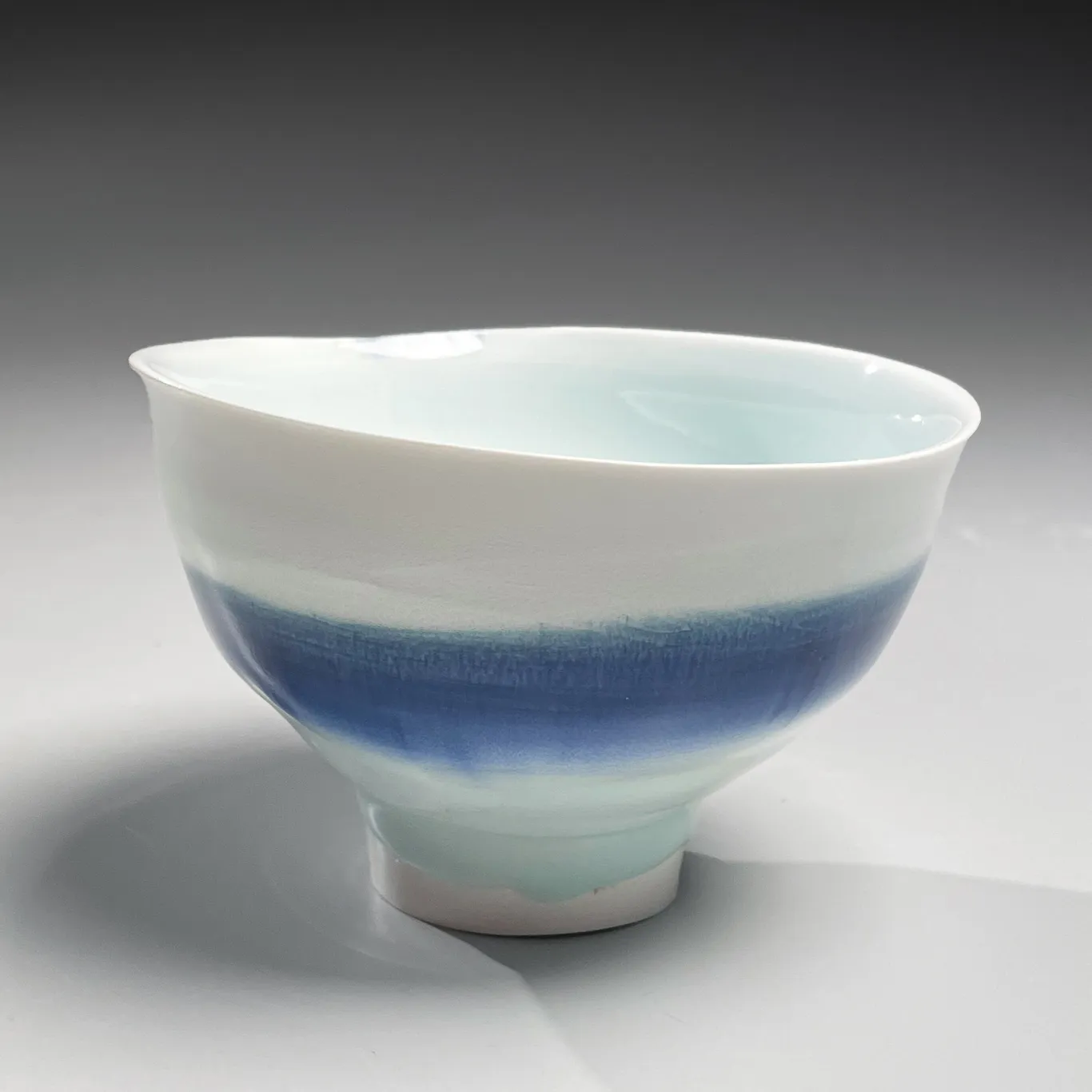 KATŌ TSUBUSA, Conical teabowl on high narrow foot with sometsuke (blue underglaze) decoration and dripping seihakuji (bluish-white) celadon glaze, 2001