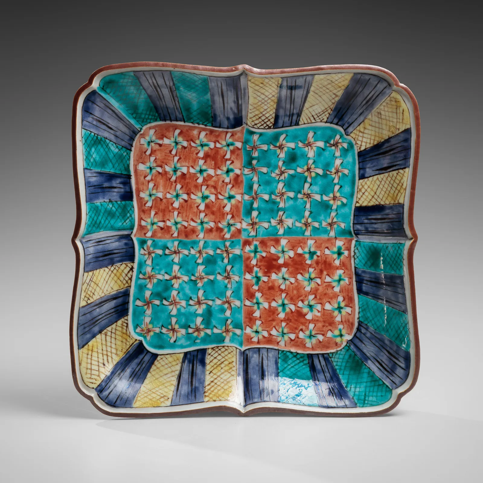 TOMIMOTO KENKICHI, Iro-e (enamel overglaze) slightly recessed rounded square platter with foliated rim, sarasatic-patterned four-petaled floral patterning, 1936