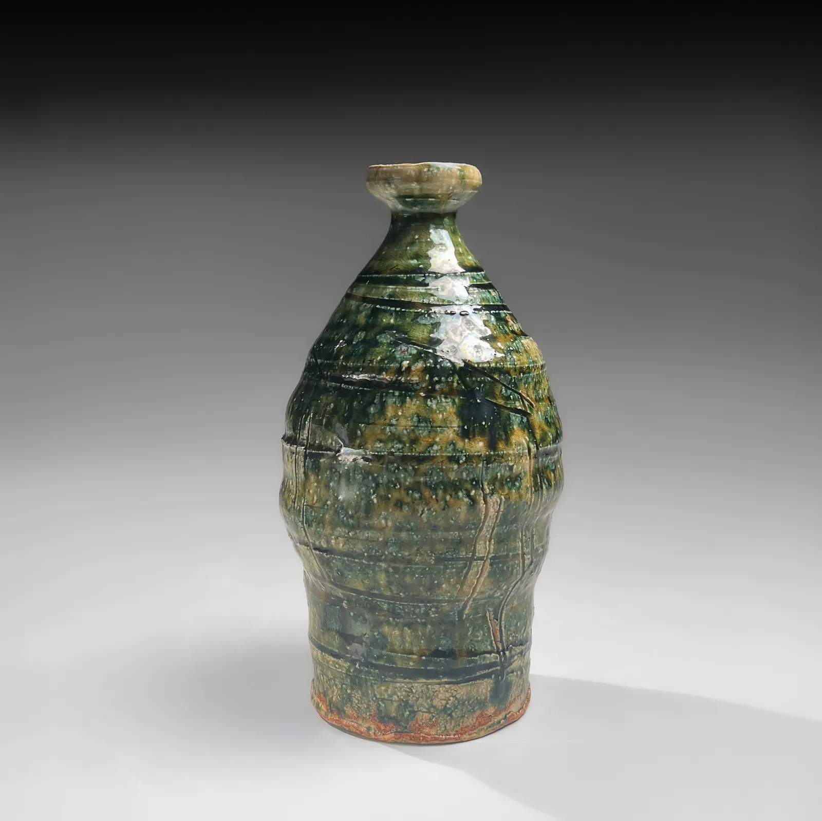 OKABE MINEO, Oribe-glazed vase with narrow neck, flaring mouth, and carved banding, 1955
