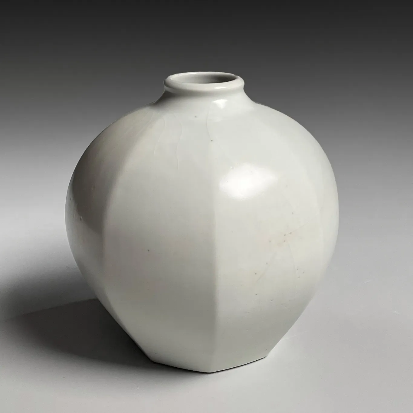 TOMIMOTO KENKICHI, Faceted white porcelain vessel with narrow, upraised neck, 1932