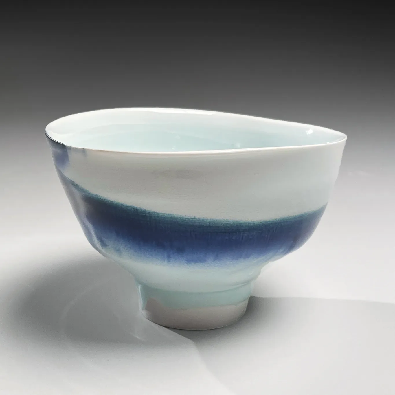 KATŌ TSUBUSA, Conical teabowl on high narrow foot with sometsuke (blue underglaze) decoration and dripping seihakuji (bluish-white) celadon glaze, 2001
