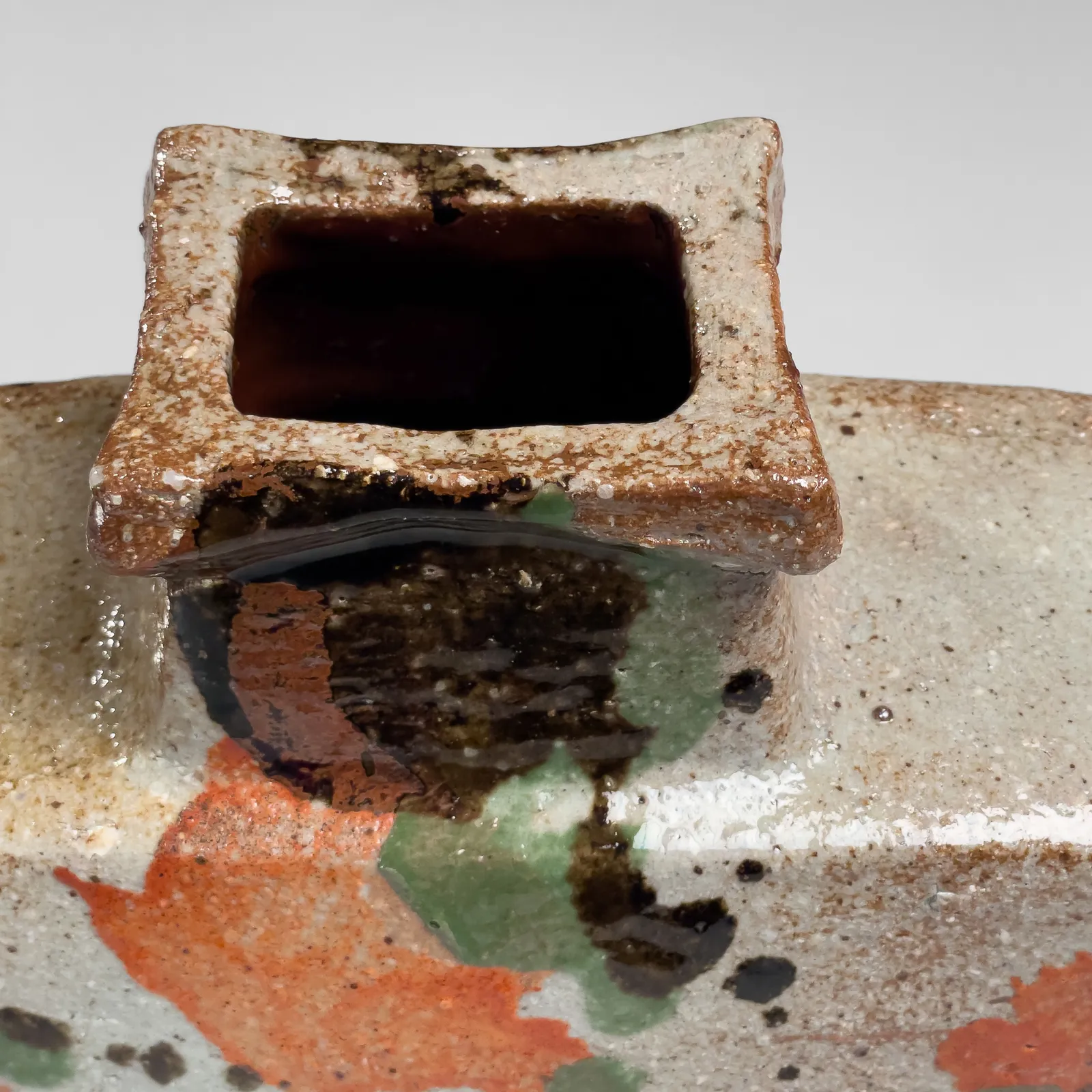 KAWAI KANJIRŌ, Flattened wide rectangular vessel with raised mouth decorated with sançai glazing, ca. 1960