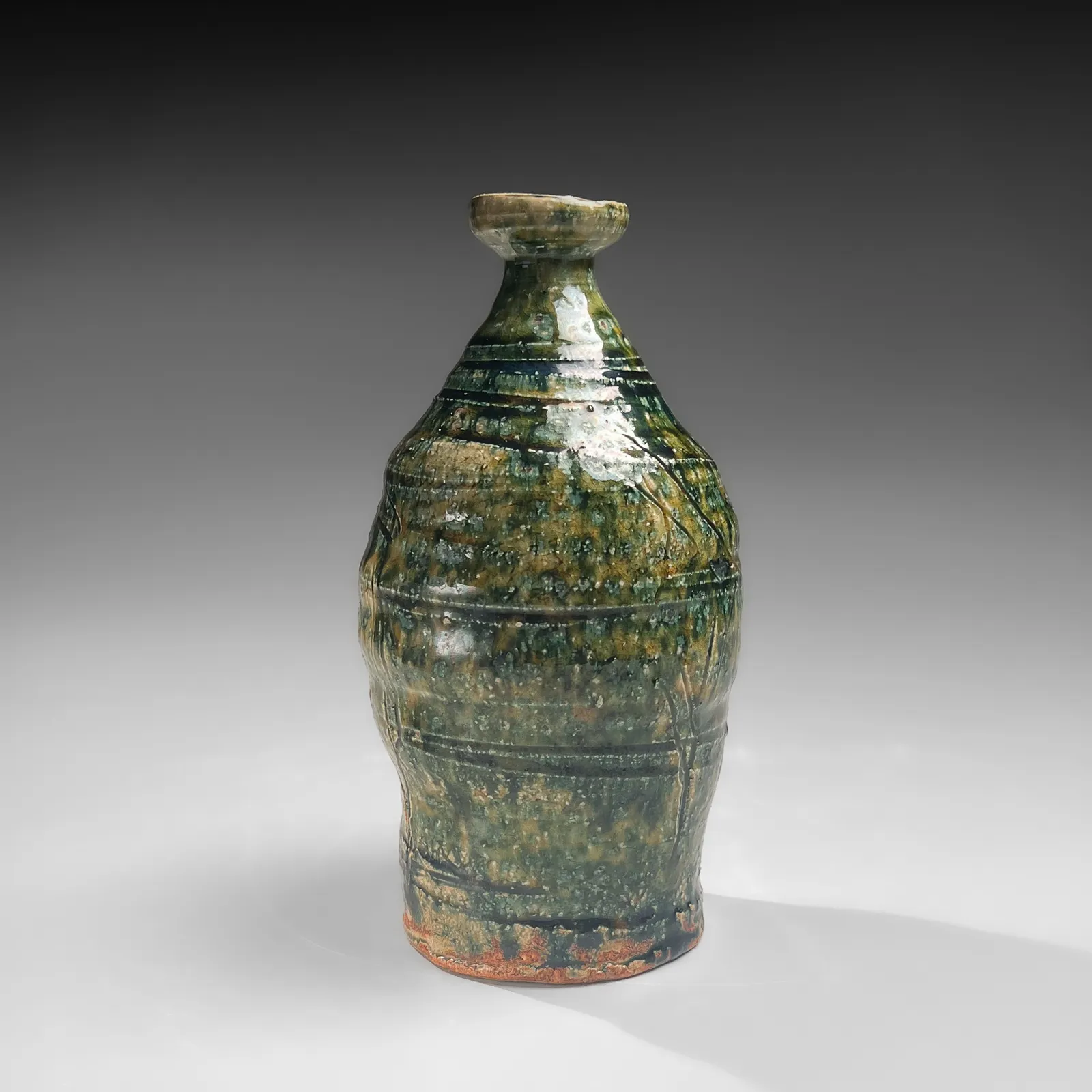 OKABE MINEO, Oribe-glazed vase with narrow neck, flaring mouth, and carved banding, 1955