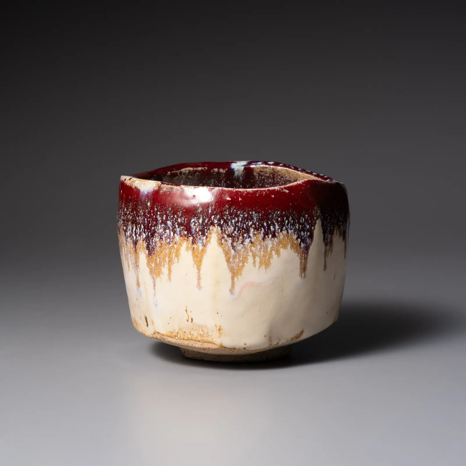 TANAKA SAJIRŌ, Faceted creamy white teabowl with dripping burgundy glaze, titled, Vermillion Cloud (Shu’un), 2025