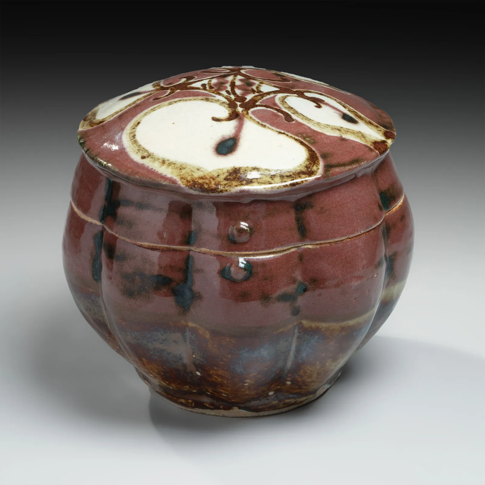 KAWAI KANJIRŌ, Red copper-glazed, lobed, covered box with floral design, ca. 1950