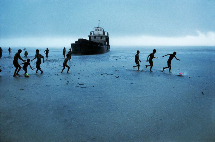 Steve McCurry, Children Playing Football with Abandoned Boat, Burma, 1995