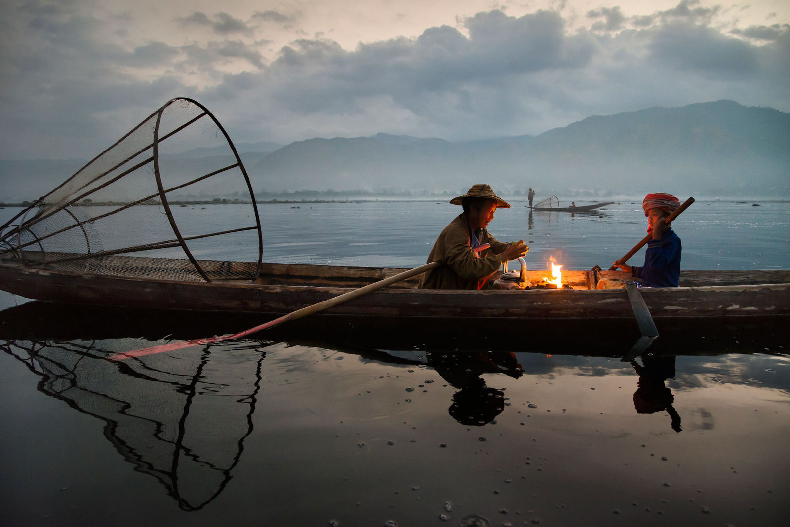 Steve McCurry, Two Fishermen by a Fire on Lake Inle, 2015