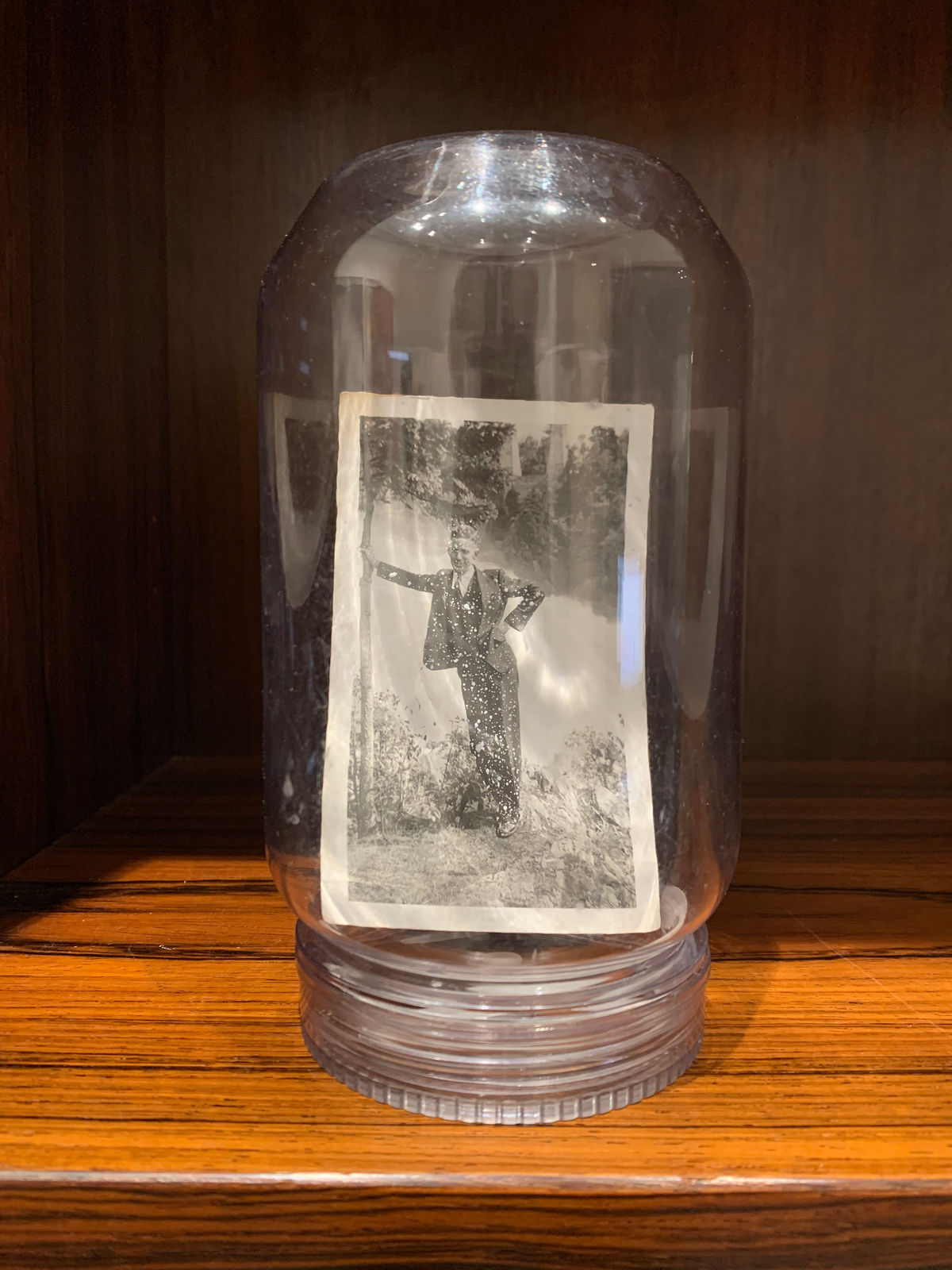 John Latour, Dapper man in three-piece suit leaning against a tree with falls in the background, 2023