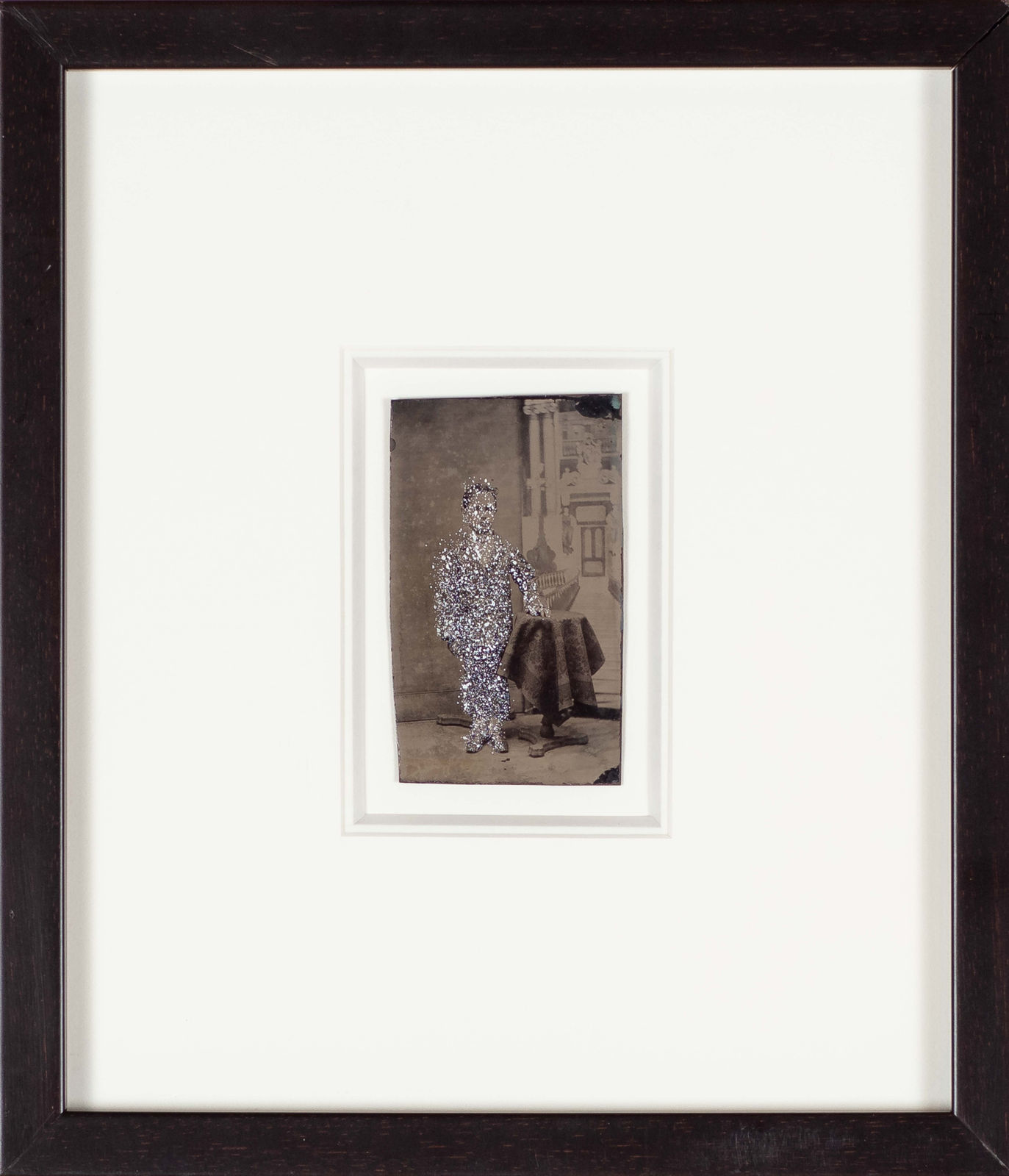 John Latour, Boy in suit resting arm on table and standing next to a Classical backdrop, 2012