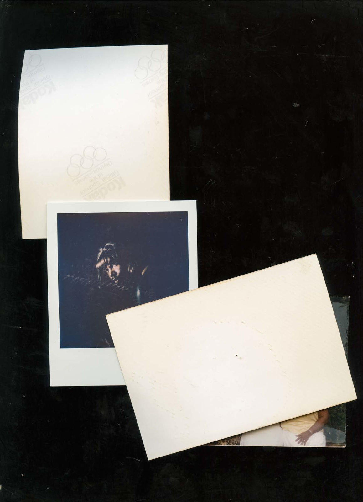 A scanned collage by Shabez Jamal showing faded or discolored family photographs intermixed with contemporary self portraits of the artist. Dust and smudges from the scanner plate surround each photograph.