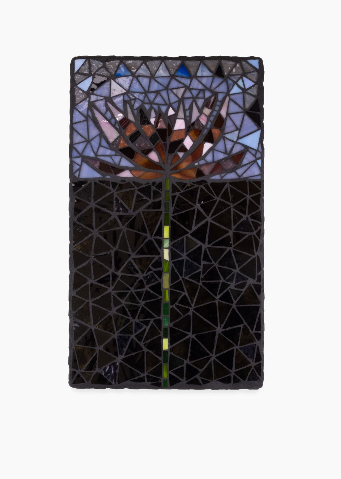 A glass mosaic created by Leah Shirley. This rectangular mosaic features water lilly emerging from a black background, green stem juxtaposing the black glass. Dark red and brown petals of the Lilly are set against a purple/blue sky.