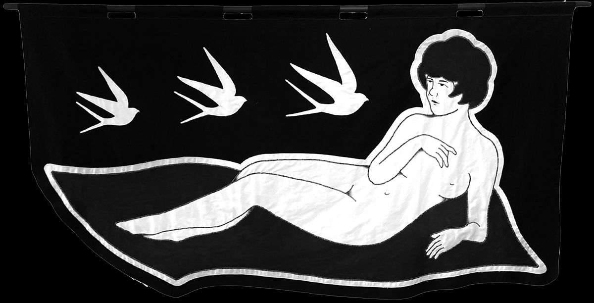 embroidered black and white banner of a nude woman reclining and three birds