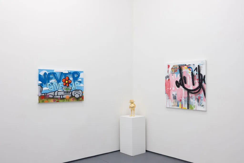 corner of a room with white walls with a gold statue on a padastal in the middle and larger paintings on each side