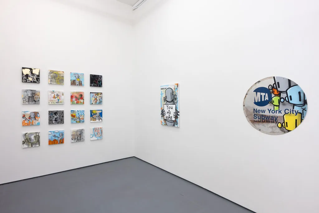 corner of gallery with white walls with a grid of colorful pieces on the left and two larger colorful pieces on the right