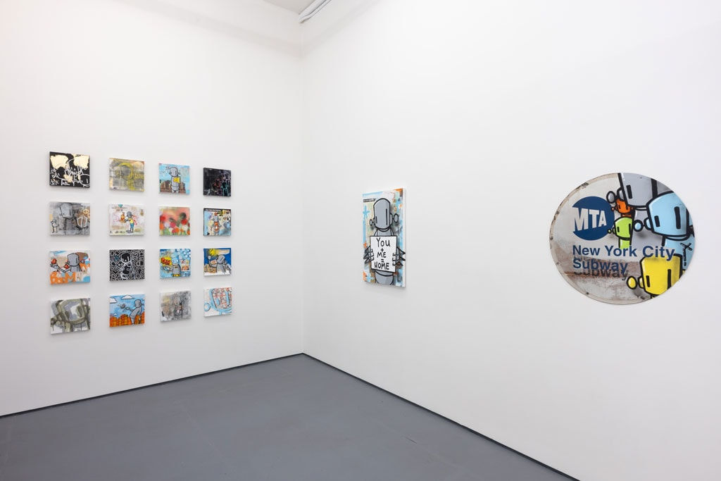 corner of gallery with white walls with a grid of colorful pieces on the left and two larger colorful pieces on the right