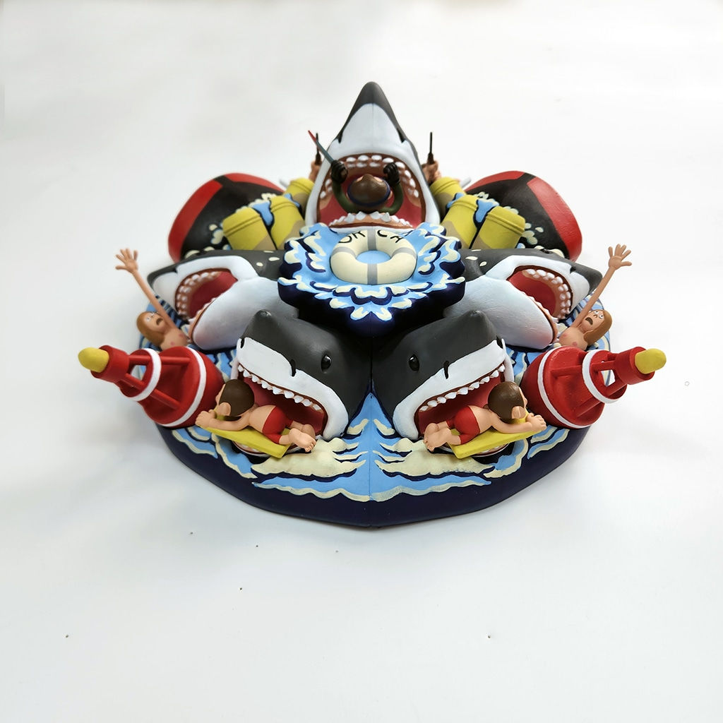 sculpture of a multiple shark heads, humans, and boats coming out towards the viewer