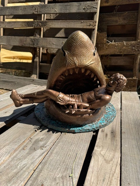 sculpture of a shark with a man in his mouth