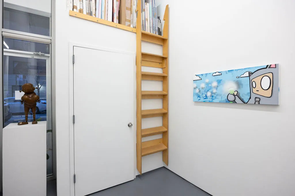 a white wall with a long blue and grey painting on the right, to its left a door and.a ladder leading to a shelf with paintings in storage and a window with a statue in it