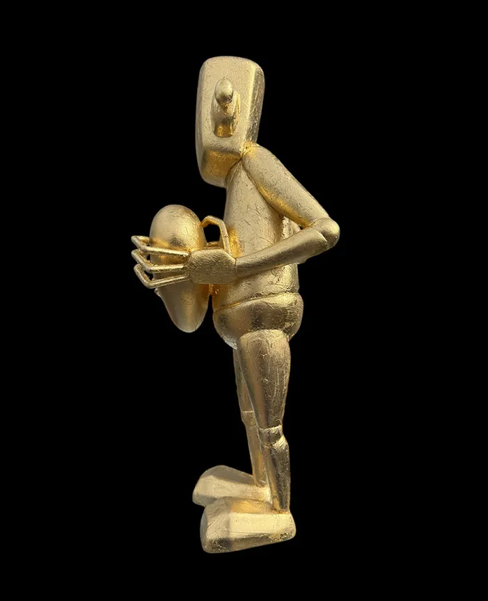 ;eft side view of a gold robot statue holding a heart