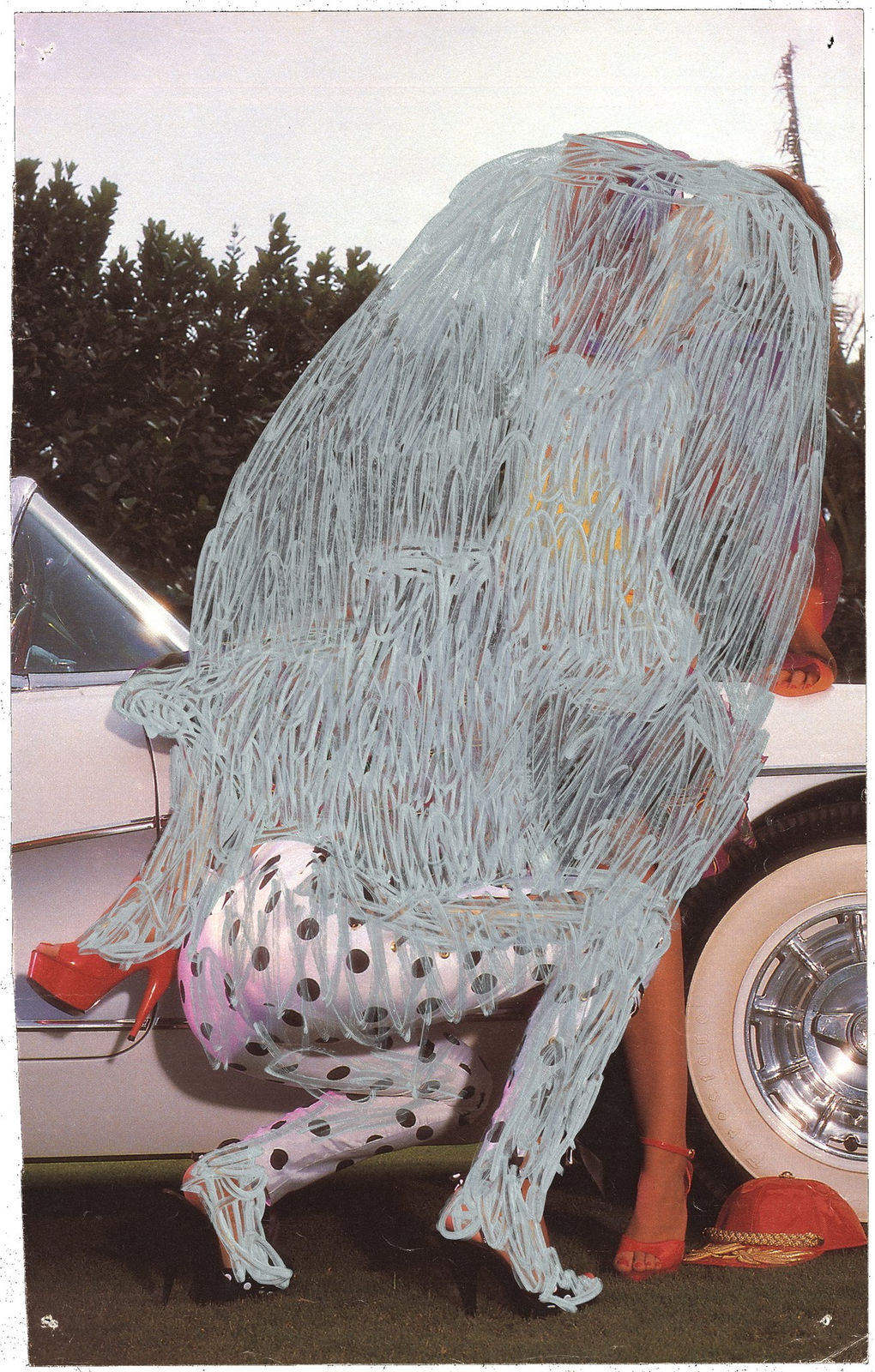 Pornographic magazine image of a woman washing a car overlaid with colored ink censoring and obscuring