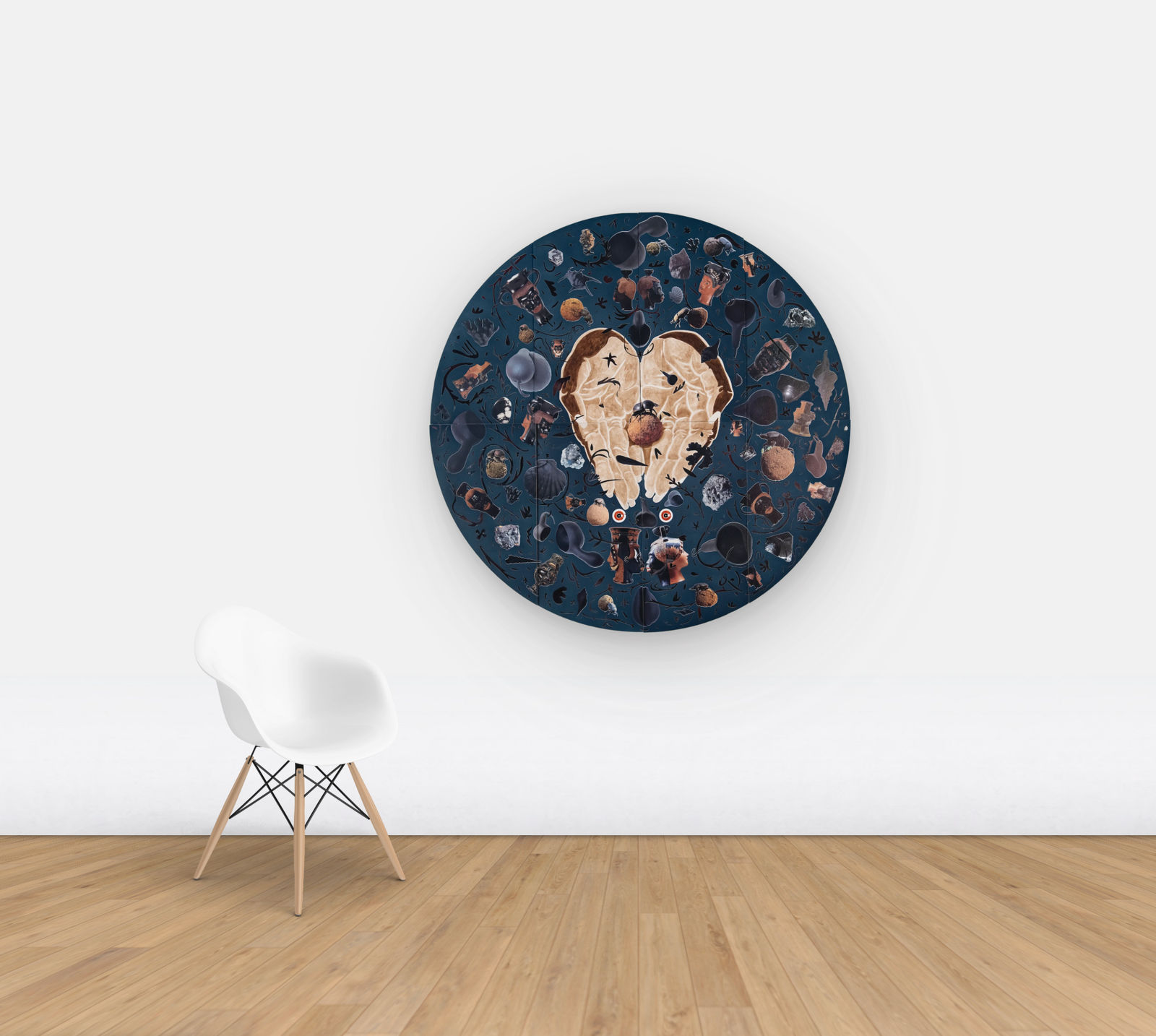 Blue velvet tondo with hands in the middle holding a dung beetle, surrounded by archeological objects hung on wall for scale