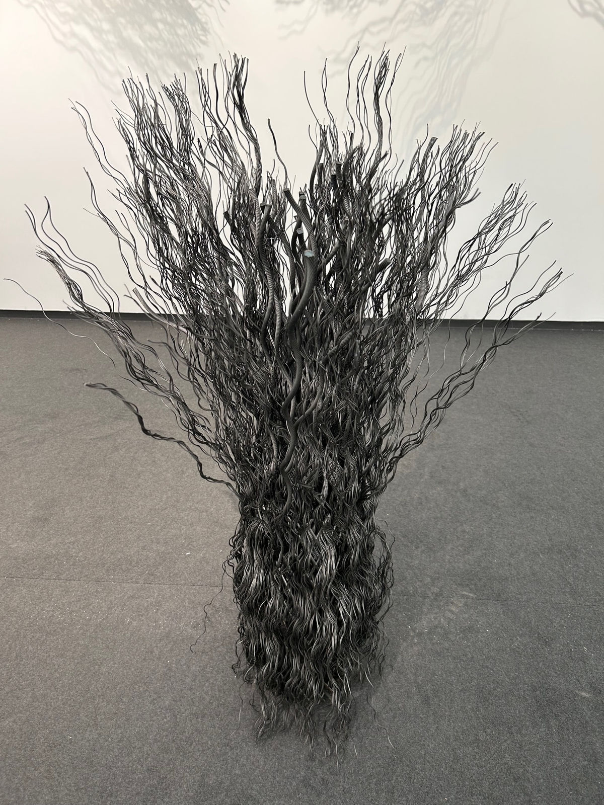 Wavy wire rope joined together to create a column unfurling at top