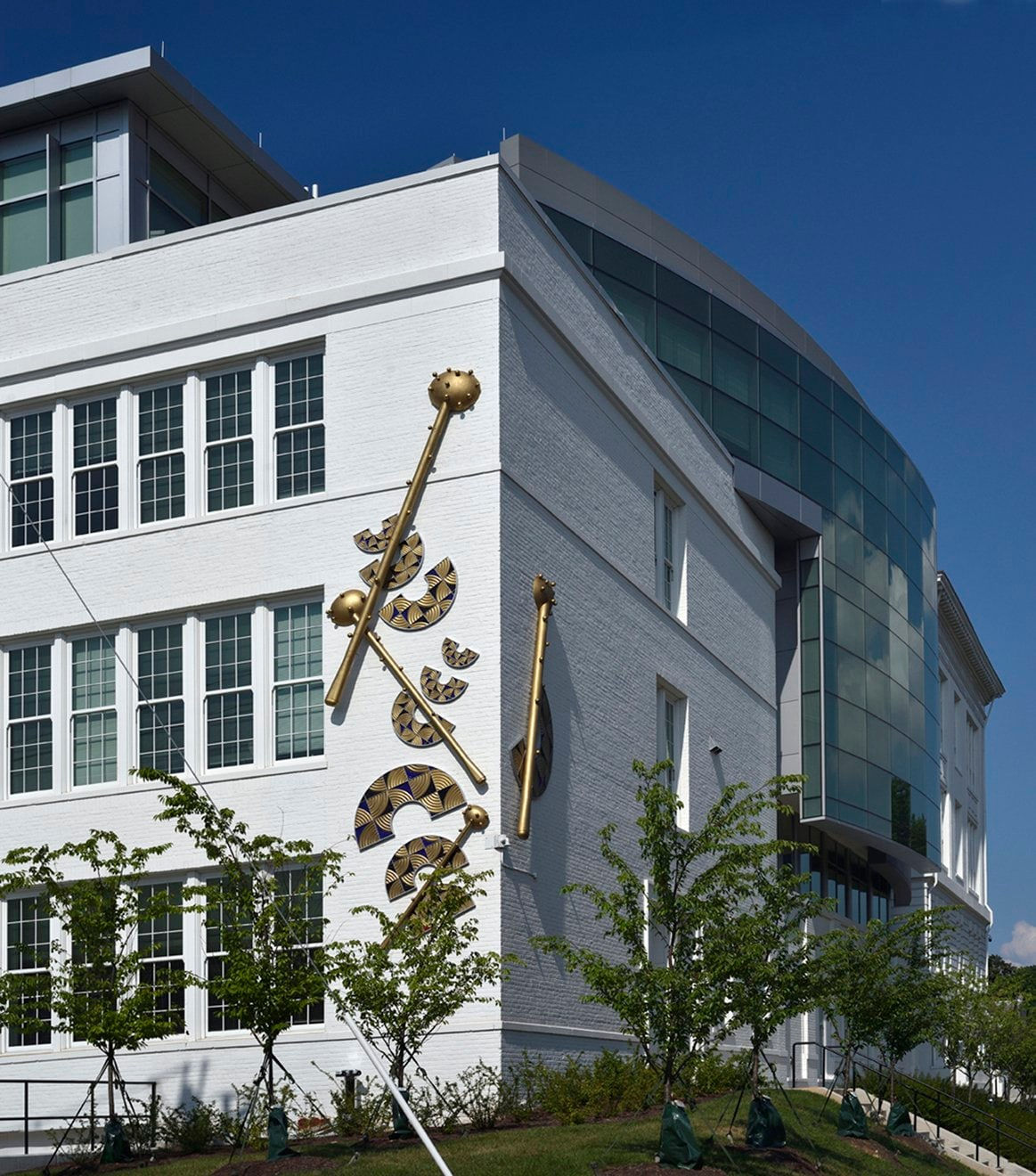 Public installation of gold semi circles and rods on a building