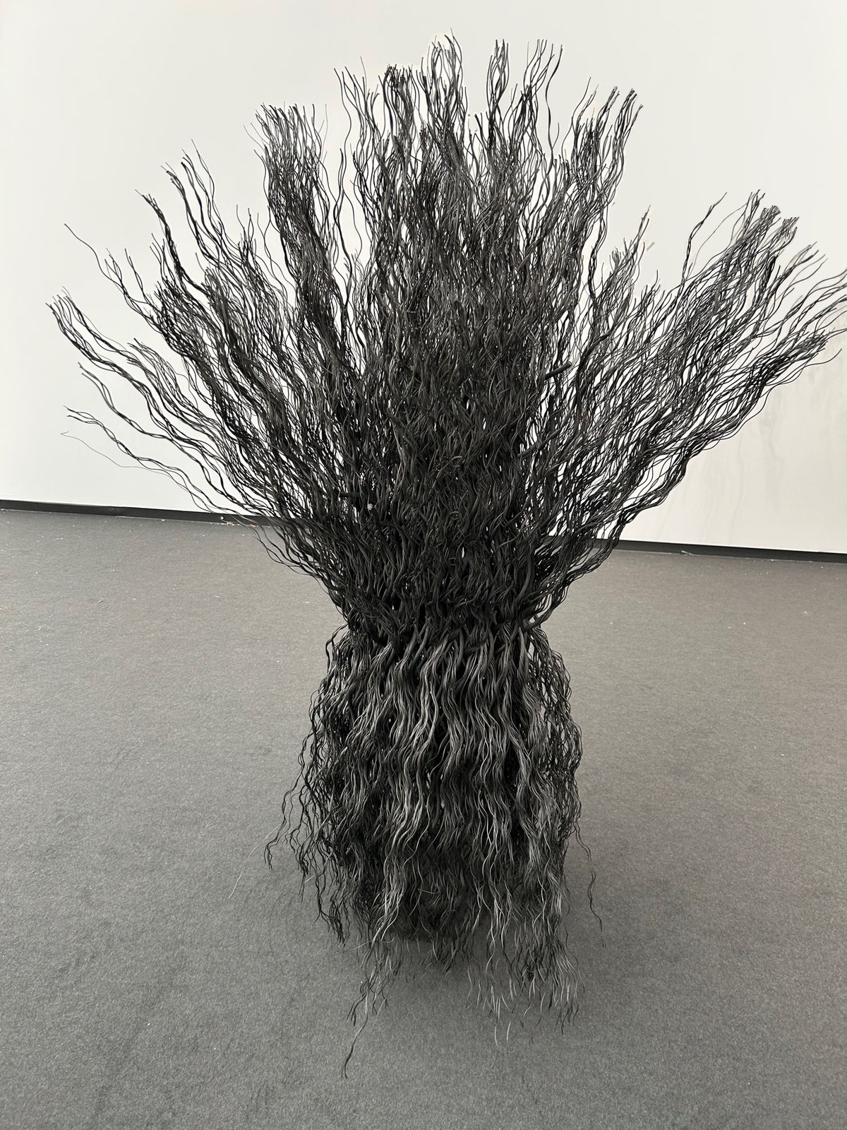 Wavy wire rope joined together to create a column unfurling at top