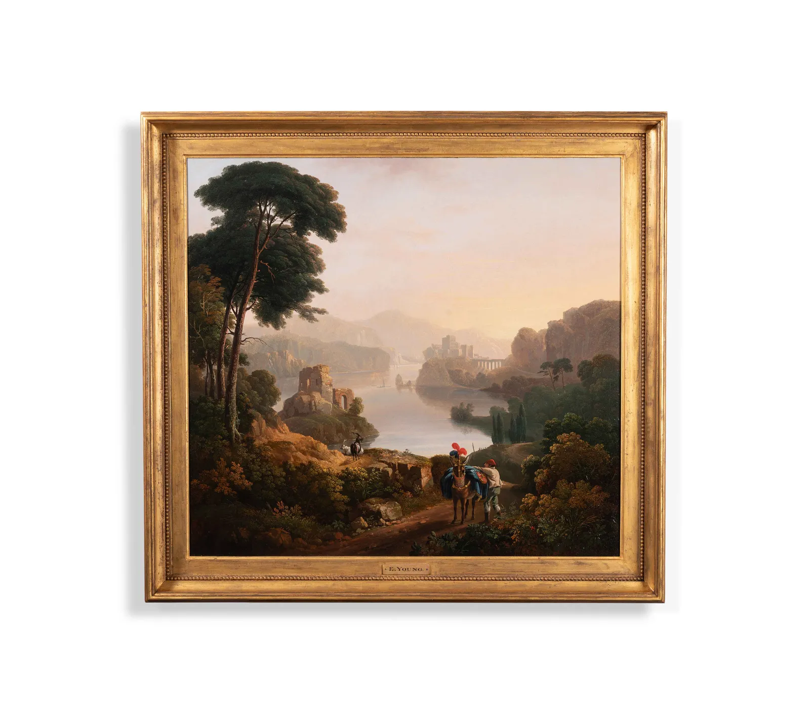 John Tobias Young (1786-1828), An Italianate landscape with a messenger & his horse on a wooded path, a lake & ancient ruins beyond