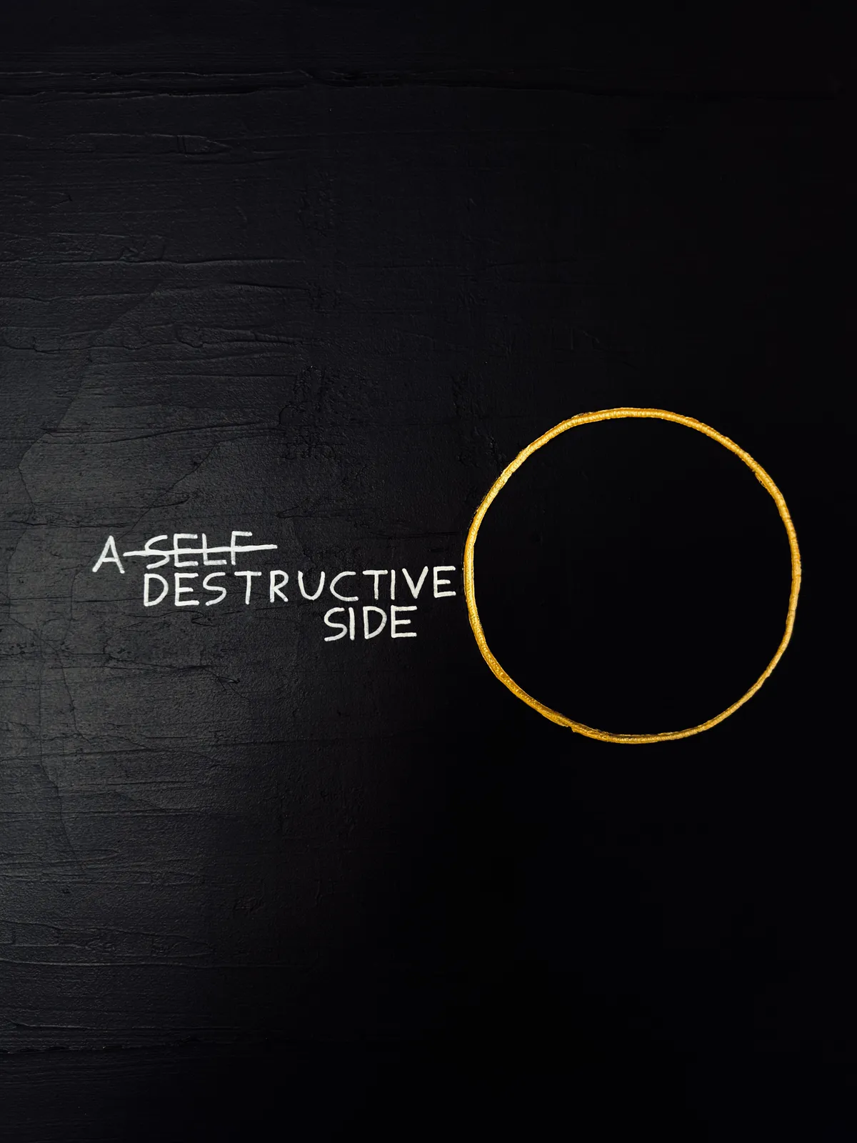 A tight close-up focusing on the hand-painted text and the yellow circle, emphasizing the raw, tactile texture of the joint compound and acrylic layers.