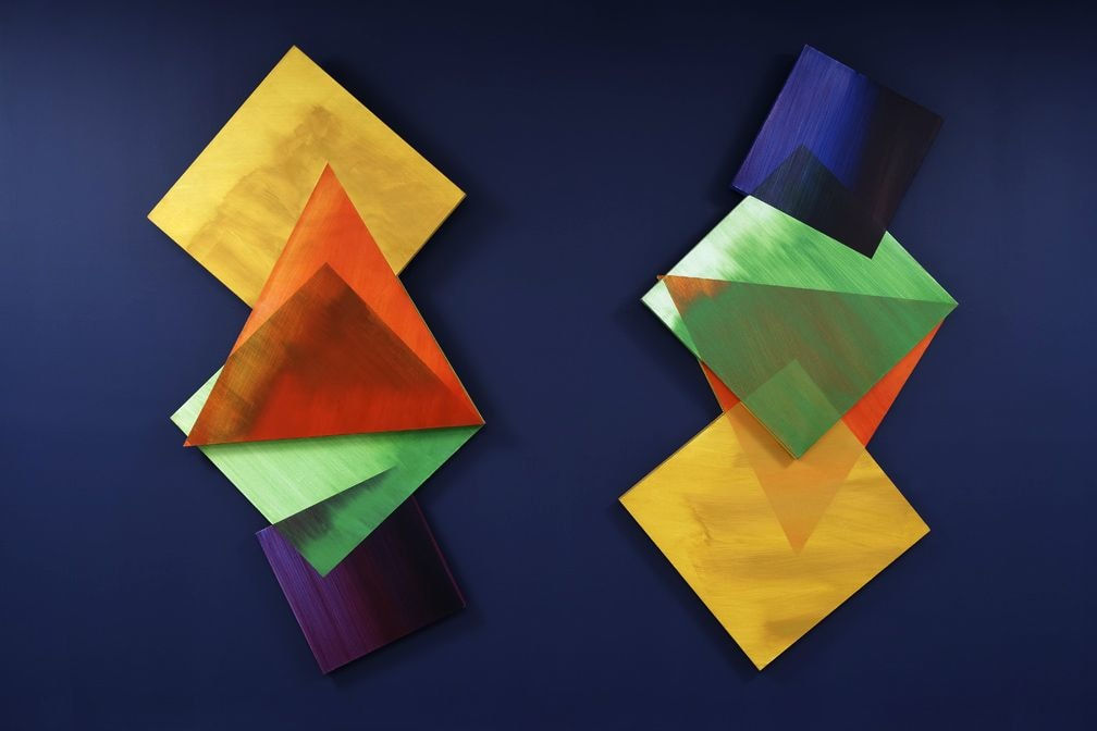 a blue painted wall with two diamond shaped paintings