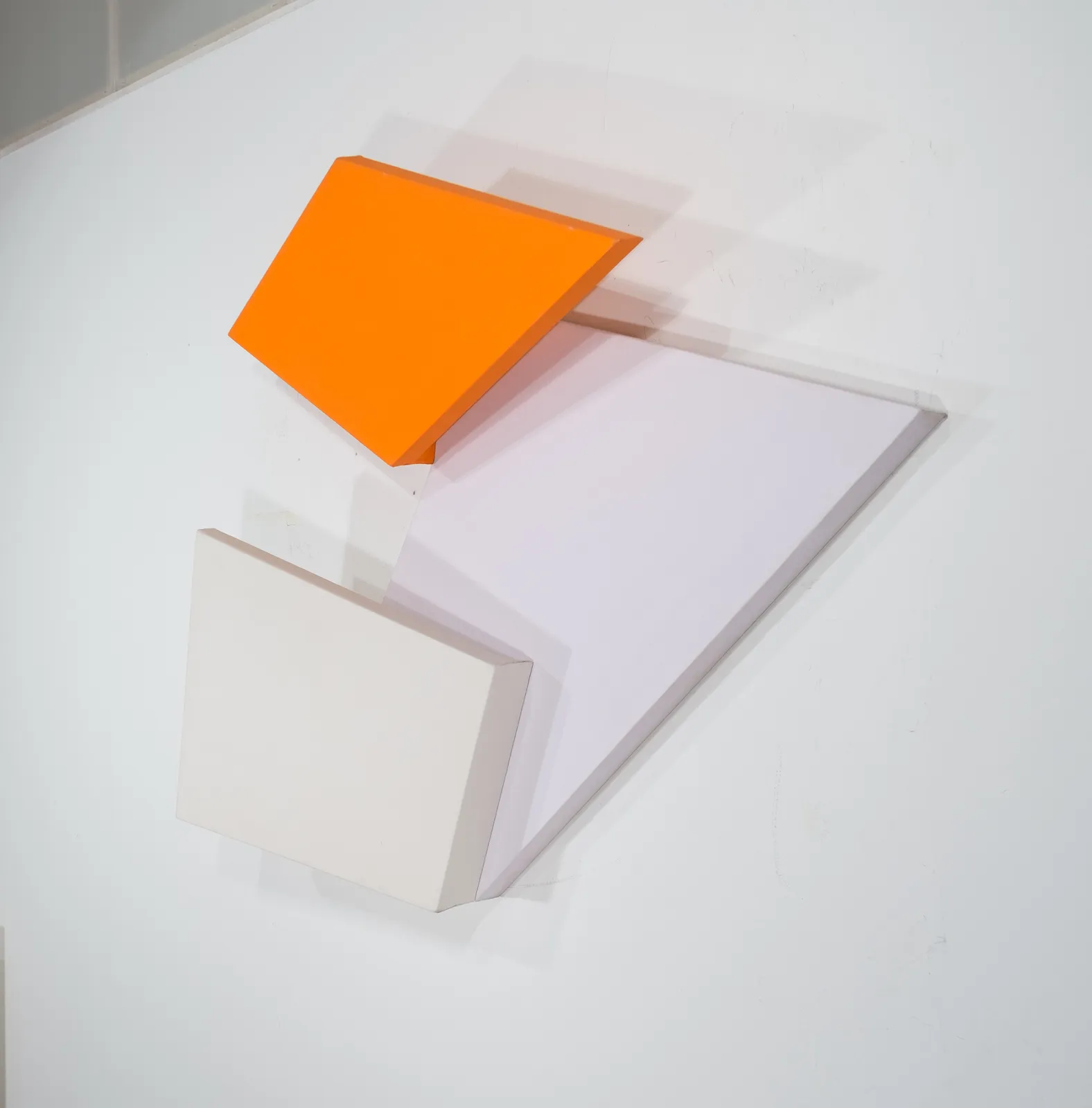 Detail of Tridimensional painting of interconnected parallelograms in orange, white, and beige
