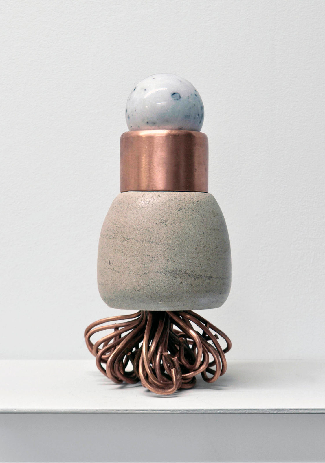 Contemporary minimalist sculpture made of stone and metal that resembles an ambiguous artifact