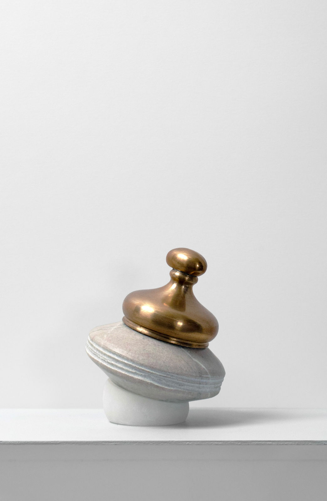 Contemporary minimalist sculpture made of stone and metal that resembles an ambiguous artifact