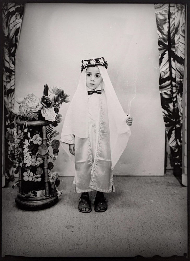 1960s black & white photograph of a young child wearing ethnic Middle-Eastern garb in a photography studio