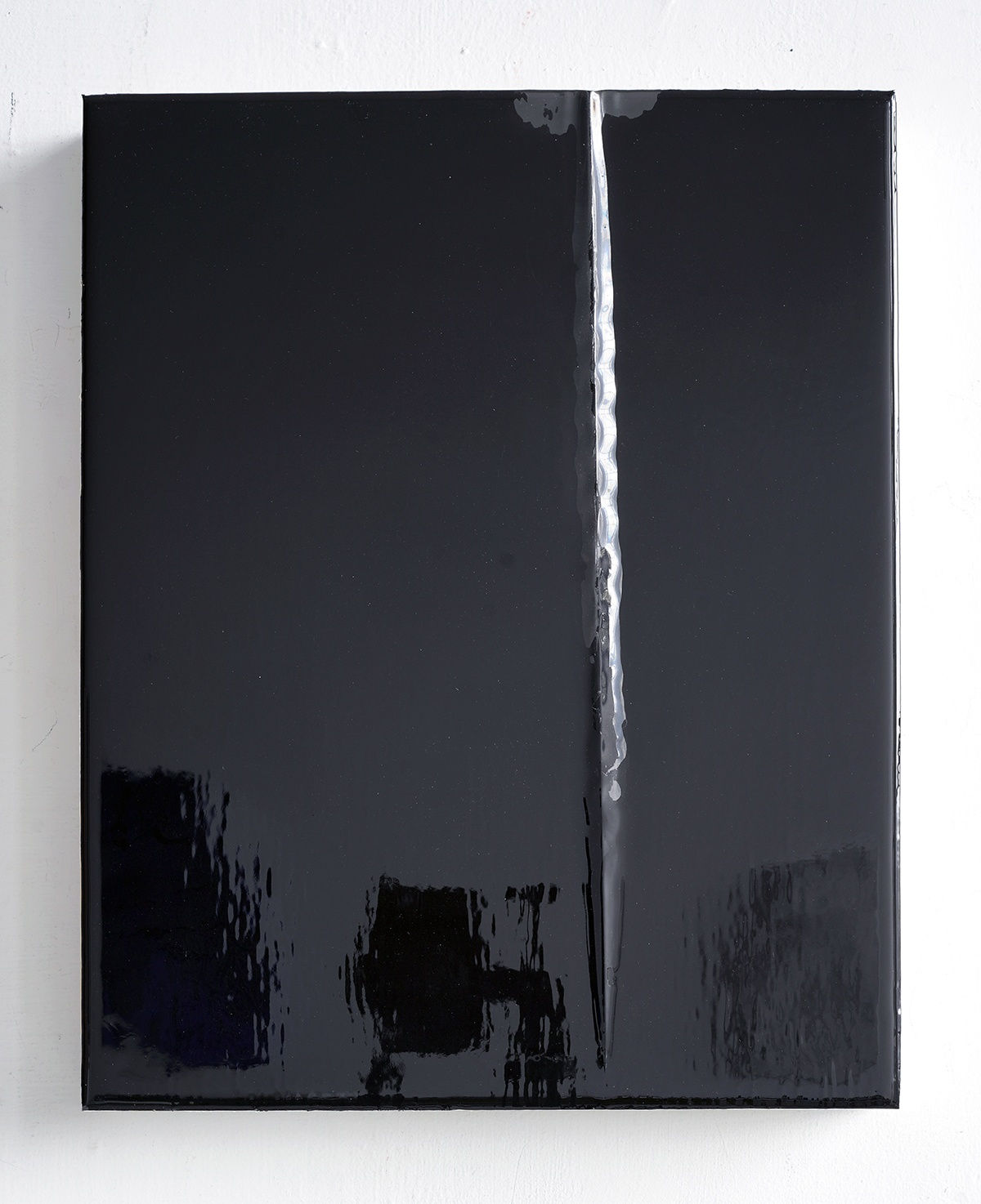 A rectangular wood panel covered in reflective black urethane resin, black vinyl, and mixed media is mounted on a white wall