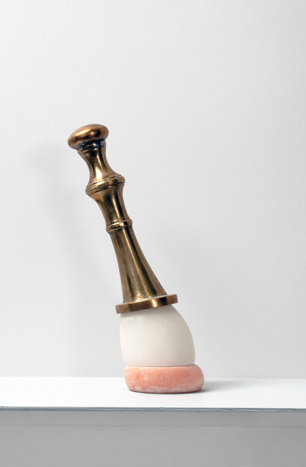 Contemporary minimalist sculpture made of stone and metal that resembles an ambiguous artifact