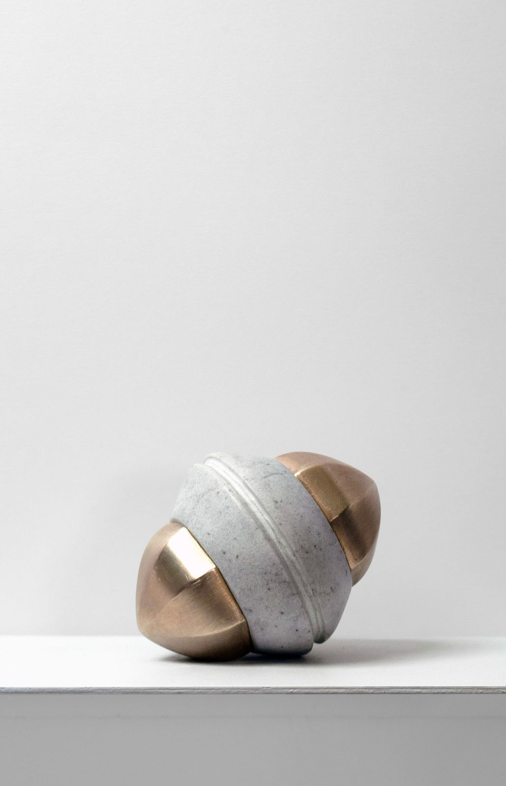 Contemporary minimalist sculpture made of stone and metal that resembles an ambiguous artifact