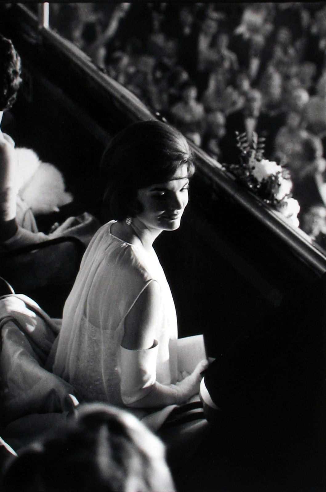 Black and white photograph with a high contrast view of Jackie Kennedy seated for the Inaugural Ball at the Armory in Washington DC