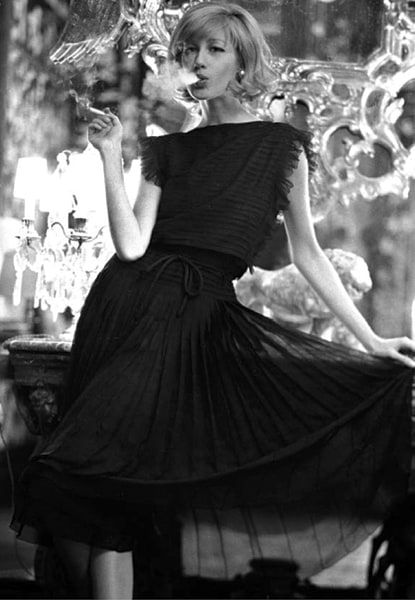 Black and white photograph of model Betty Catroux in a Chanel Dress smoking a cigarette