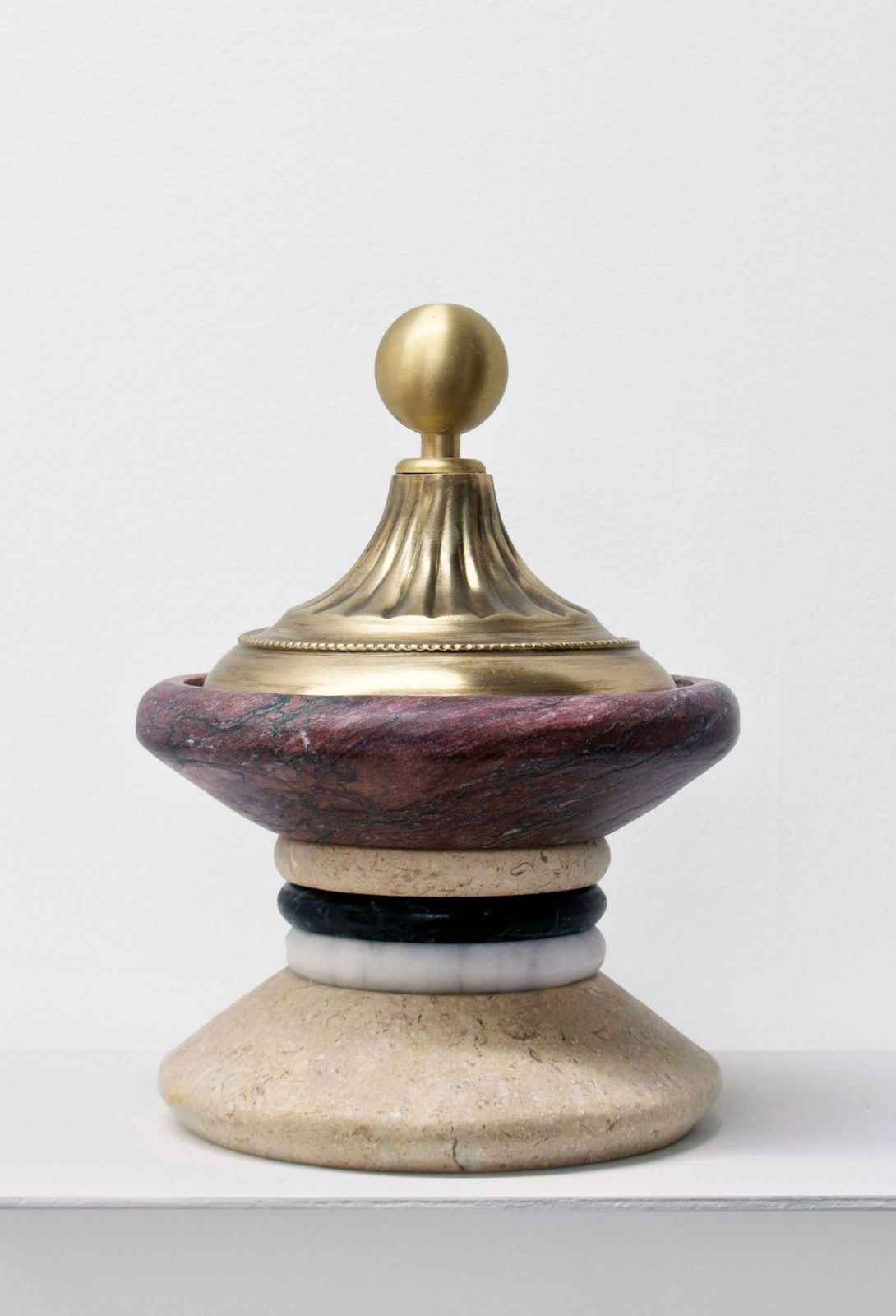 Contemporary minimalist sculpture made of stone and metal that resembles an ambiguous artifact