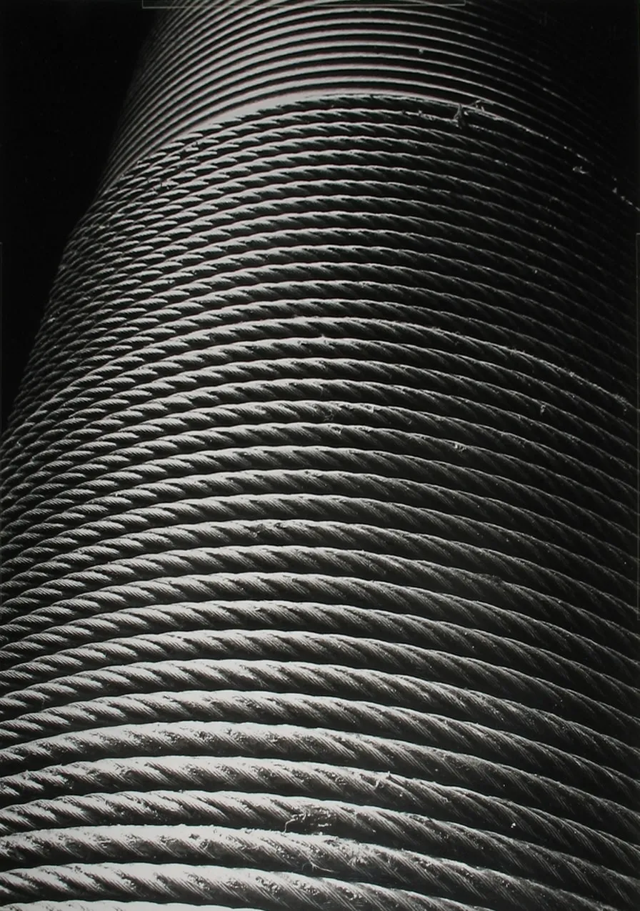 Black and white close-up photograph of a rope coiled in a cylinder shape