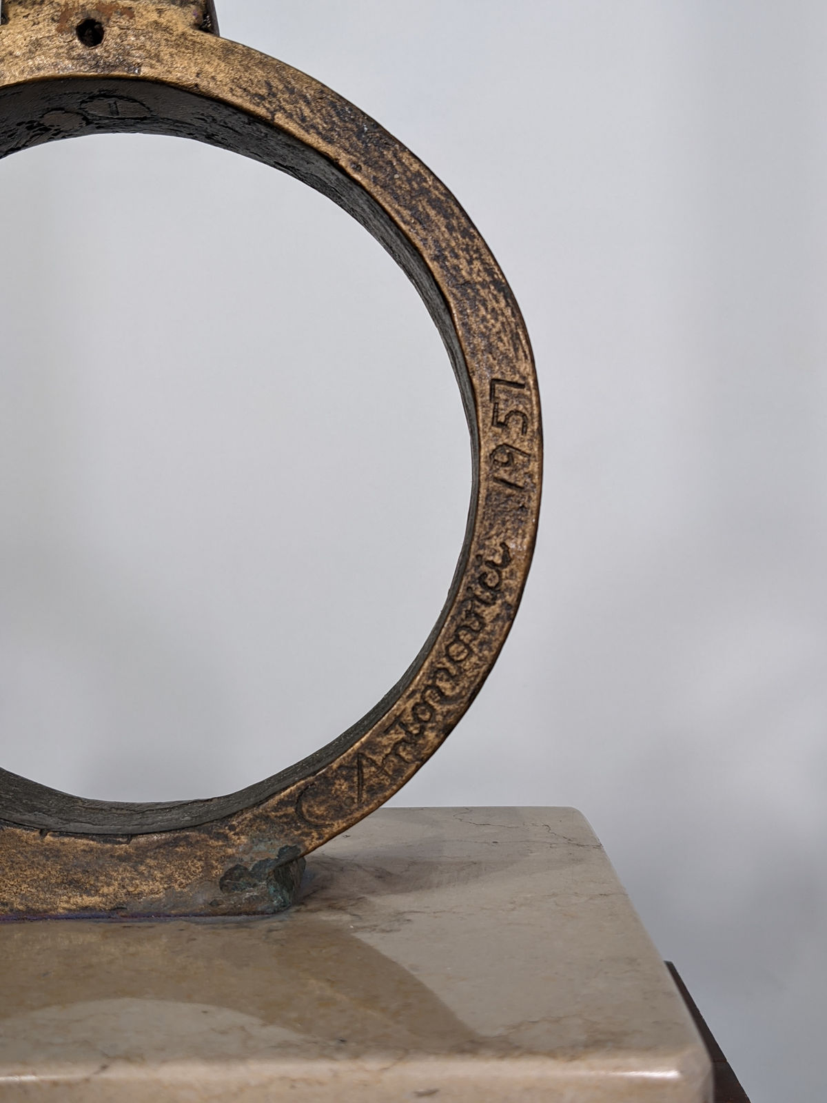 Detail Modernist bronze sculpture of stylized owl represented by vertical bar, one eye open, one closed, on circular perch