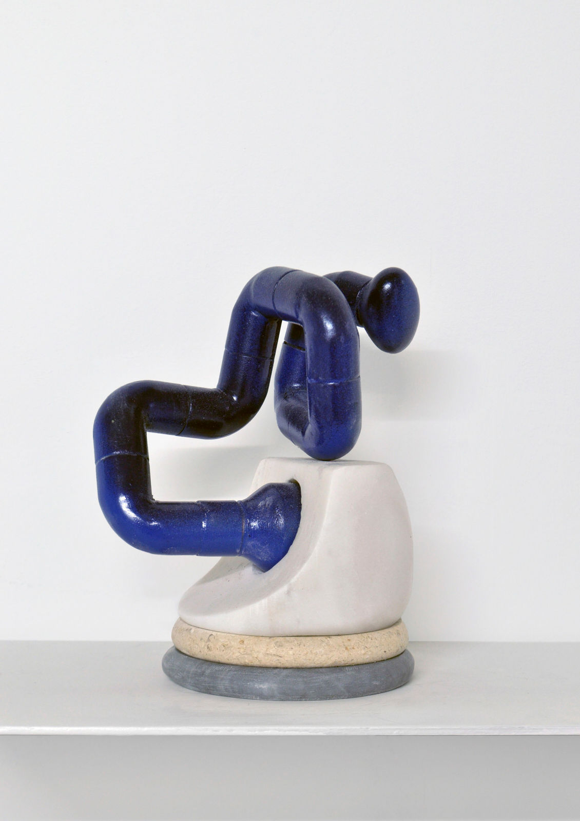 Contemporary minimalist sculpture made of stone and metal that resembles an ambiguous artifact